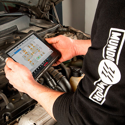 Hombre sujetando una tablet comprobando el estado de un motor