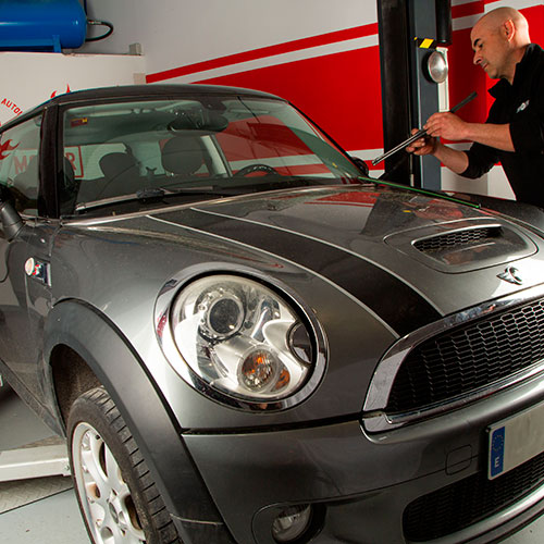 Coche marca Mini de color gris dentro de un taller